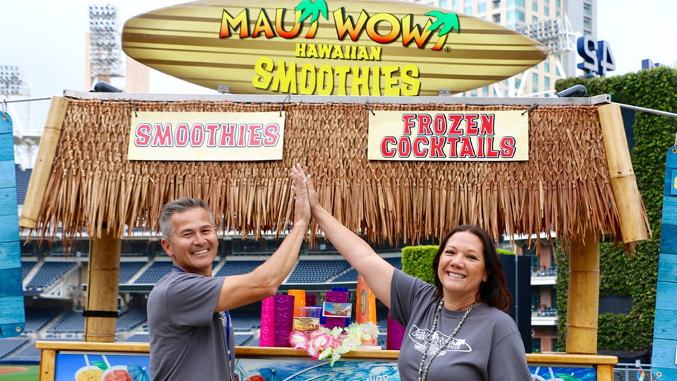 Low-cost franchise opportunity with happy Maui Wowi franchisees high-fiving.