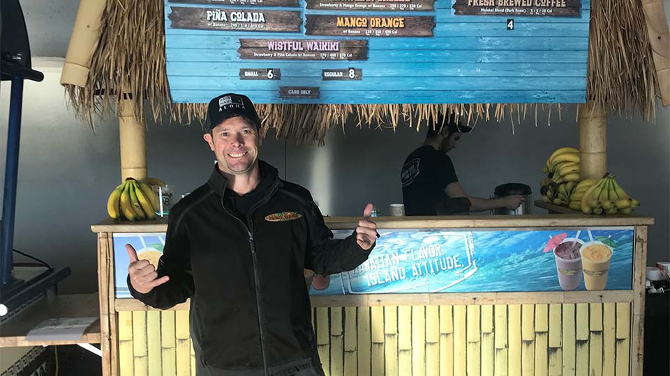 Maui Wowi franchise standing in front of a kiosk aloha spirit